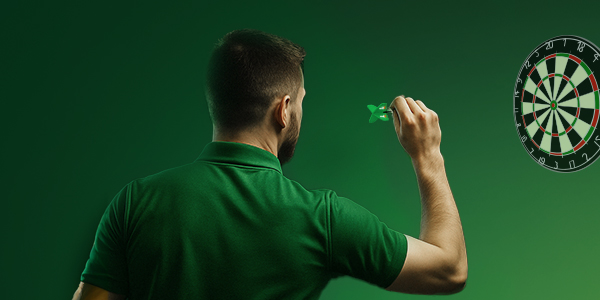 Dartspeler in groene polo richt zich op het dartbord