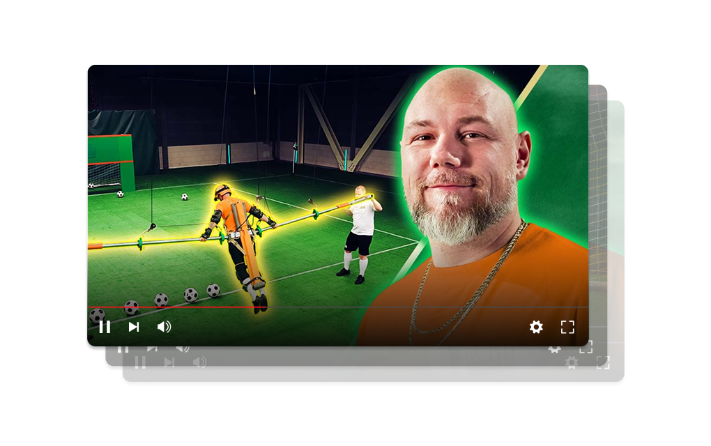 Levend tafelvoetbalspel met human-size spelers op een groene speelveld, bal aan het rollen