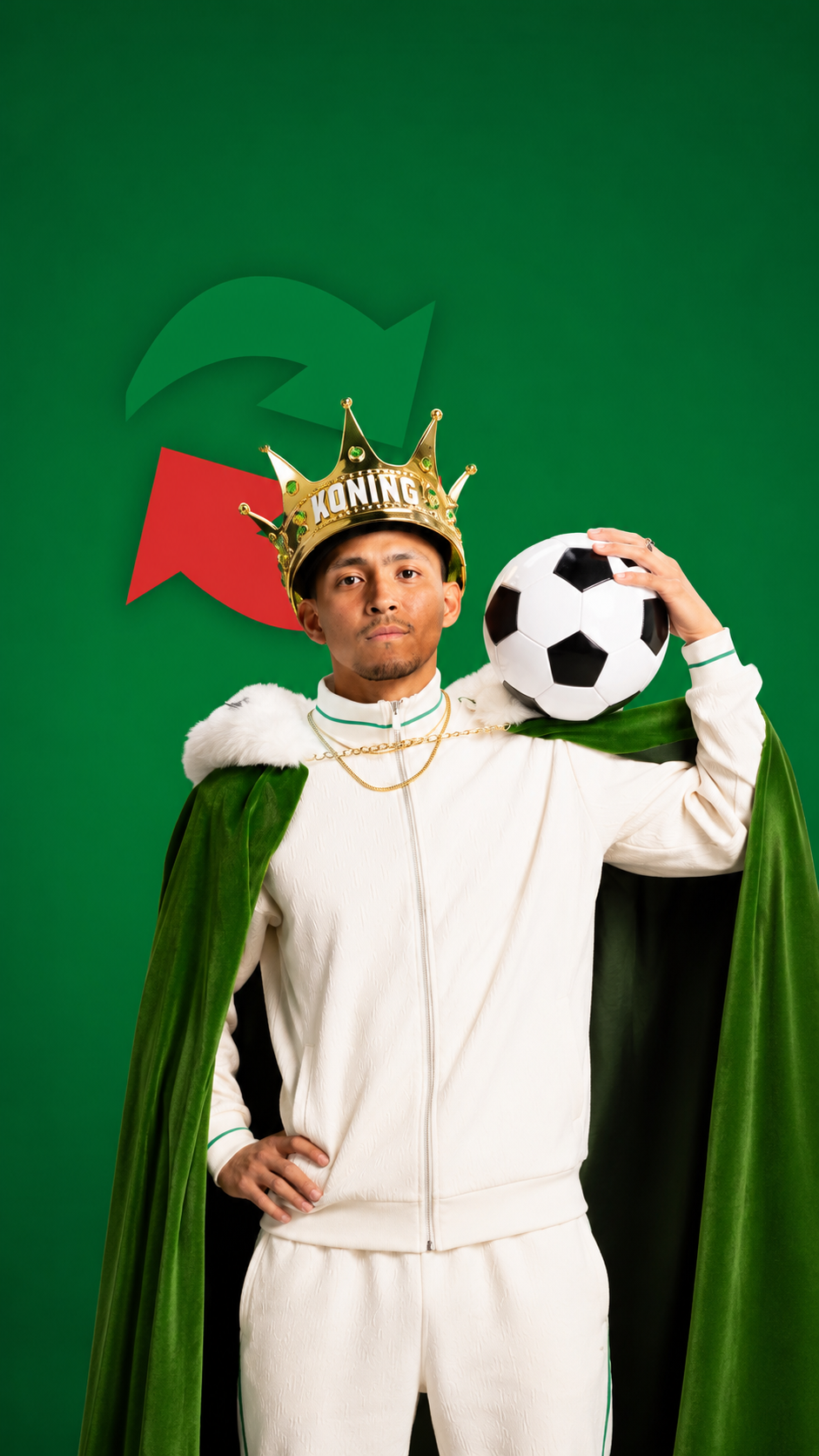 Man in sportoutfit met kroon KONING en groene mantel met voetbal op schouder